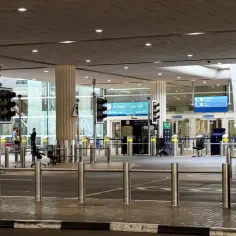 Puste lotnisko w Dubaju, oznaki "Arrivals" i sygnalizacja świetlna. Koronawirus w Dubaju wpłynął na ruch lotniczy.