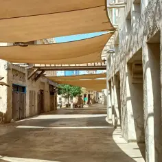 Ulica Al Seef w Dubaju, z tradycyjnymi budynkami i płóciennymi zadaszeniami tworzącymi cień.