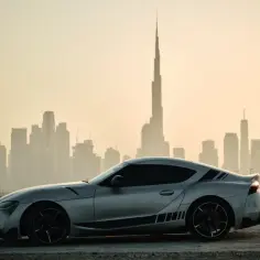 Srebrne sportowe auto na tle panoramy Dubaju. Idealne do wynajem samochodu Dubaj.