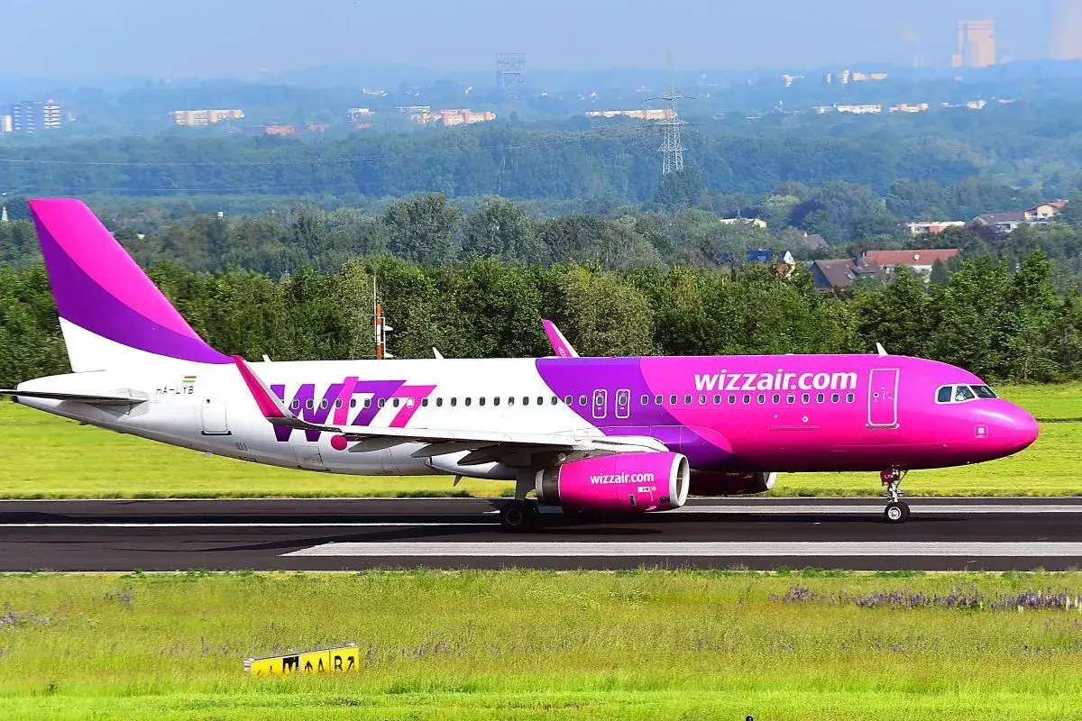 Różowy samolot Wizz Air na pasie startowym. Zastanawiasz się, wizz discount club co to? To program lojalnościowy dla podróżnych.
