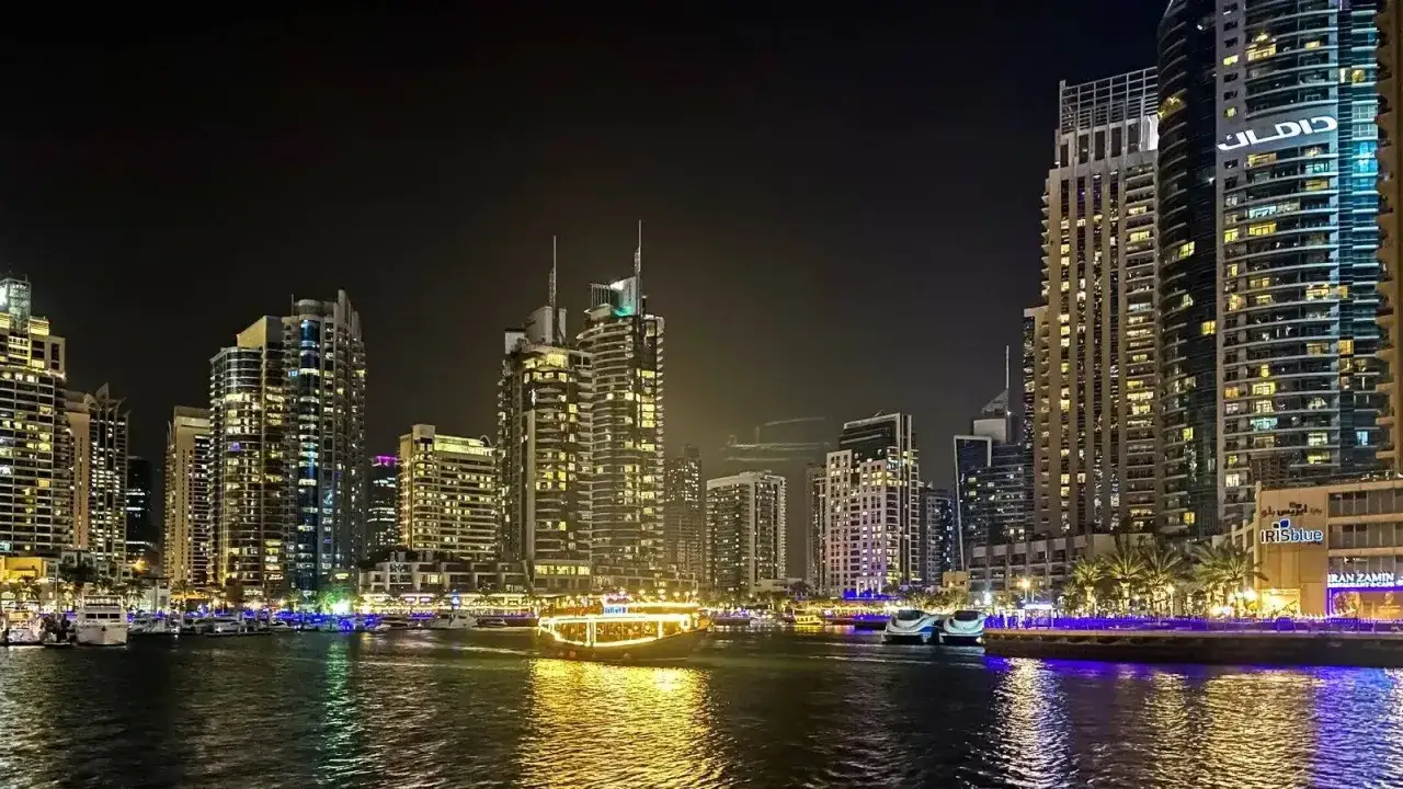 Wieczorem w Dubaju, lśniące drapacze chmur i łodzie na wodzie. Czy warto jechać do Dubaju? Widok mówi sam za siebie!